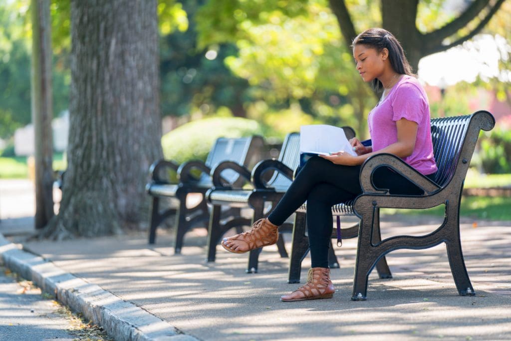 Student studying on campus bench