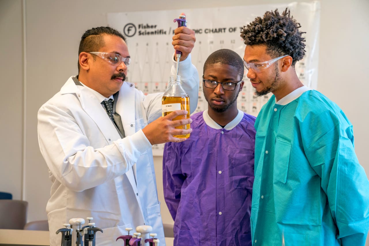 Students and professor working in science classroom