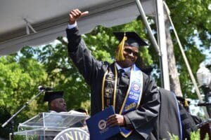 Student holding diploma smiling