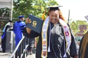 Student holding diploma smiling